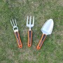 Yard Force Gartenwerkzeug-Set: Handrechen, Pflanzkelle und Grabegabel mit orangen Griffen auf Rasen.