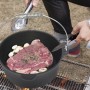 Schwarzer El Fuego Dutch Oven (3,5 l) aus Gusseisen mit Speisen auf einem Grill.