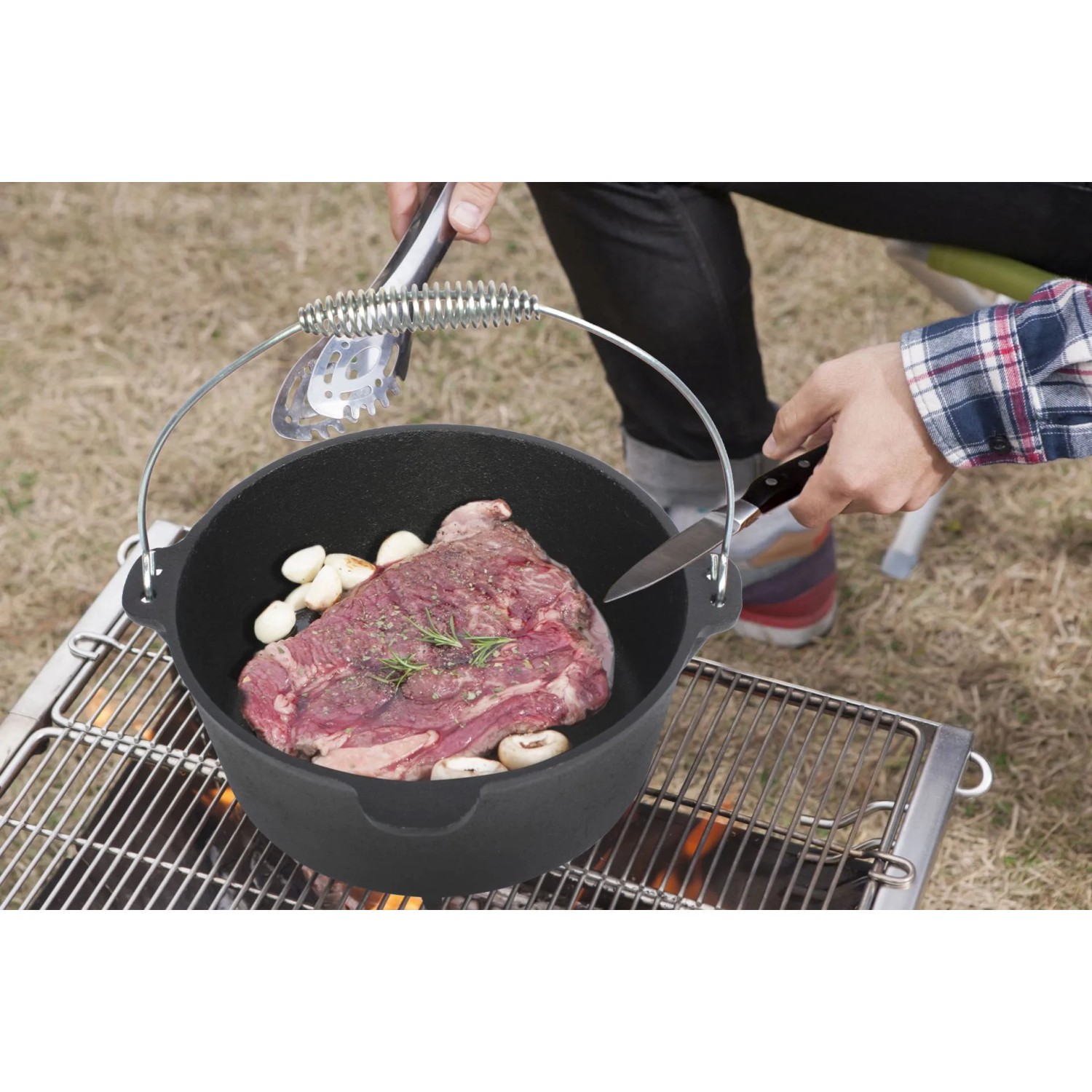 Schwarzer El Fuego Dutch Oven (3,5 l) aus Gusseisen mit Speisen auf einem Grill.