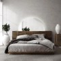 Halbrunder Tulup LED Wandspiegel mit warmweißer Beleuchtung über einem Bett. Dekorativer, rahmenloser Spiegel für Schlafzimmer.