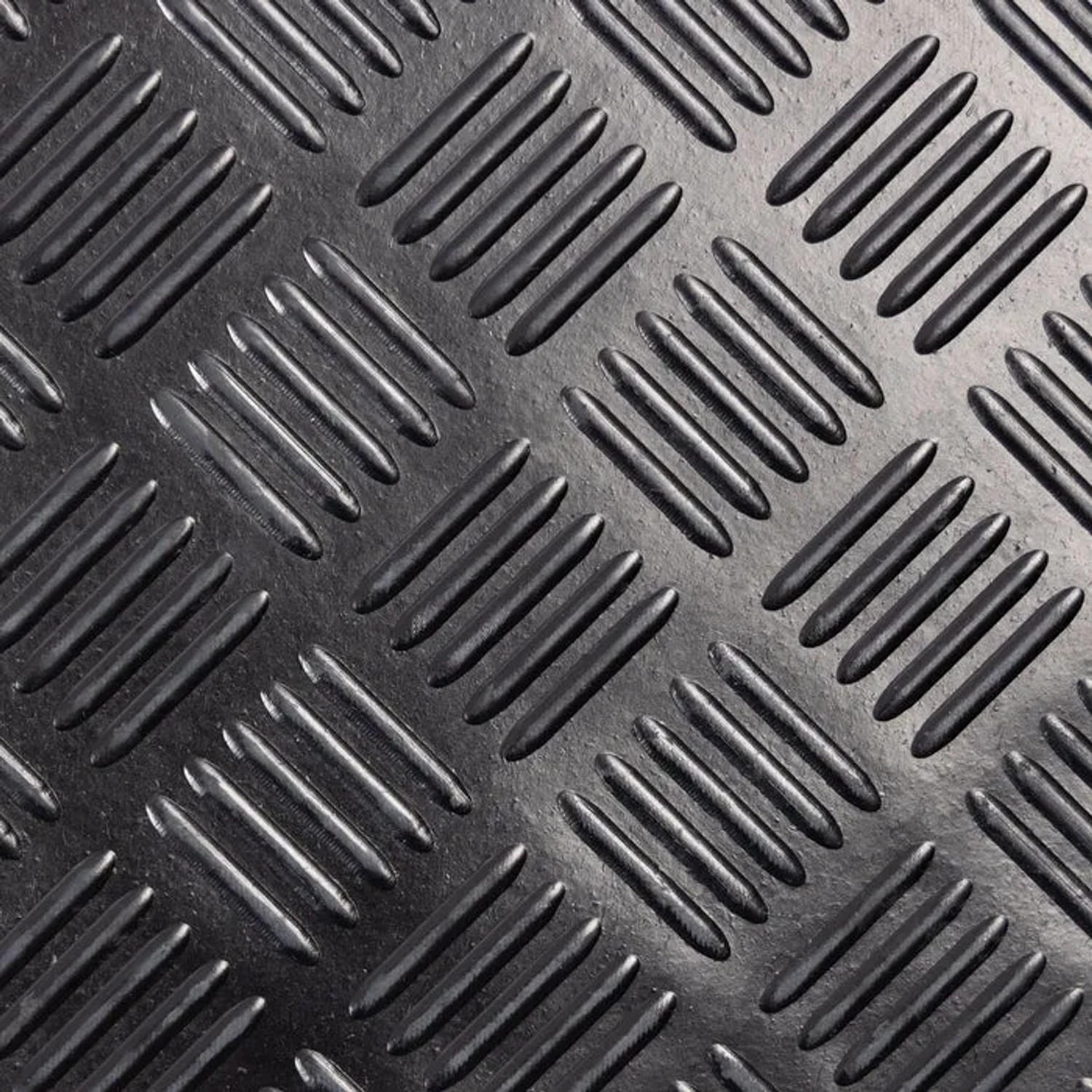 Detailaufnahme einer schwarzen KARAT Gummimatte mit Karo-Muster. Rutschfester PVC-Bodenbelag.