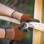 Hände mit LUX Multi Handschuhen (Gr. 7) beim Schrauben in Holz. Arbeitshandschuhe für Heimwerker.