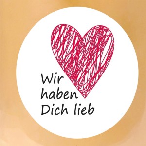 Detailansicht der HS Candle Duftkerze mit Herz und Schriftzug "Wir haben Dich lieb".