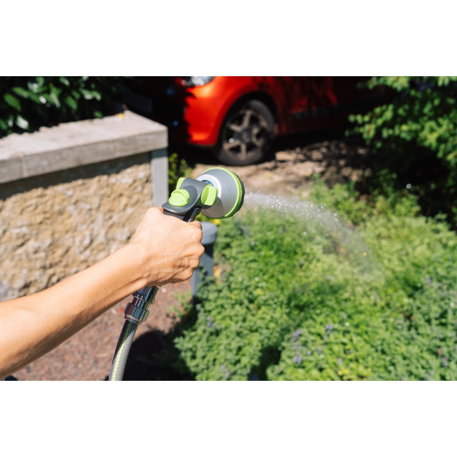 Geka Multibrause Plus 5S Grau in Aktion: Hand hält Gartenspritze beim Bewässern von Pflanzen.