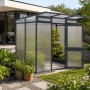 KGT Gewächshaus Anthrazit-Grau im Garten. Begehbares Pflanzenhaus mit transparenter Wand, offener Tür und Pflanzen.