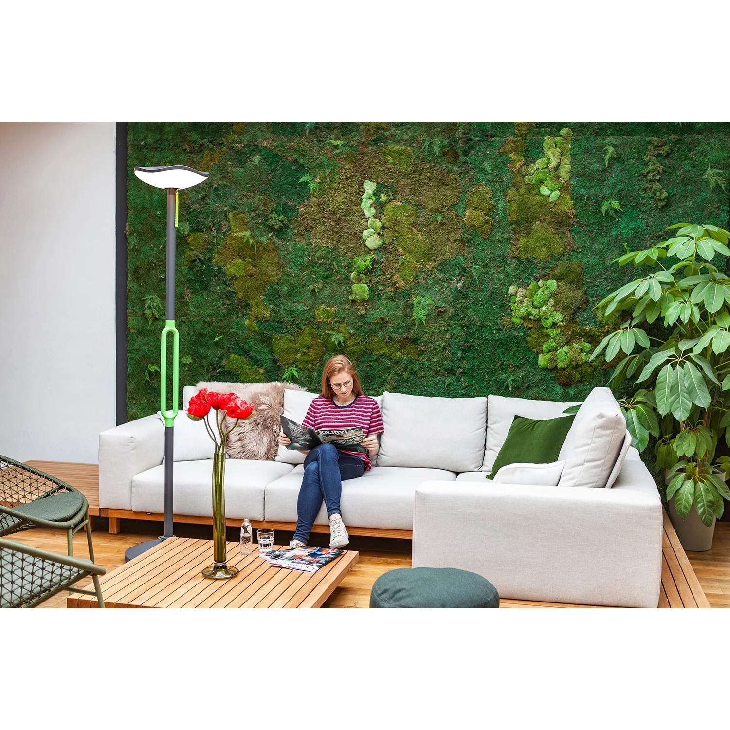 Lutec LED Solar Stehleuchte Poppy, anthrazit-grün, neben einer Frau auf einem Sofa im Wohnzimmer.