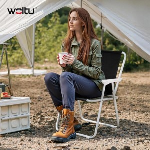 Frau sitzt entspannt auf WOLTU Klappstuhl beim Camping. Leichter, schwarzer Angelstuhl mit weißem Gestell.