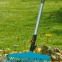 Gardena Combisystem Komplettangebot: Rechenbesen mit Holzstiel im Einsatz auf Rasen mit Laub.