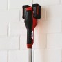 Einhell Akku-Sense Agillo Power X-Change Solo mit zwei Akkus an einer Wandhalterung.