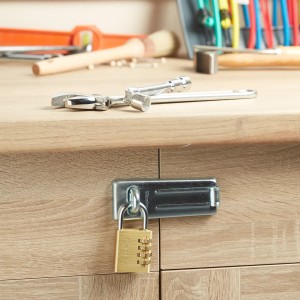 Master Lock Vorhängeschloss 604EURD aus Messing an einer Schranktür befestigt.