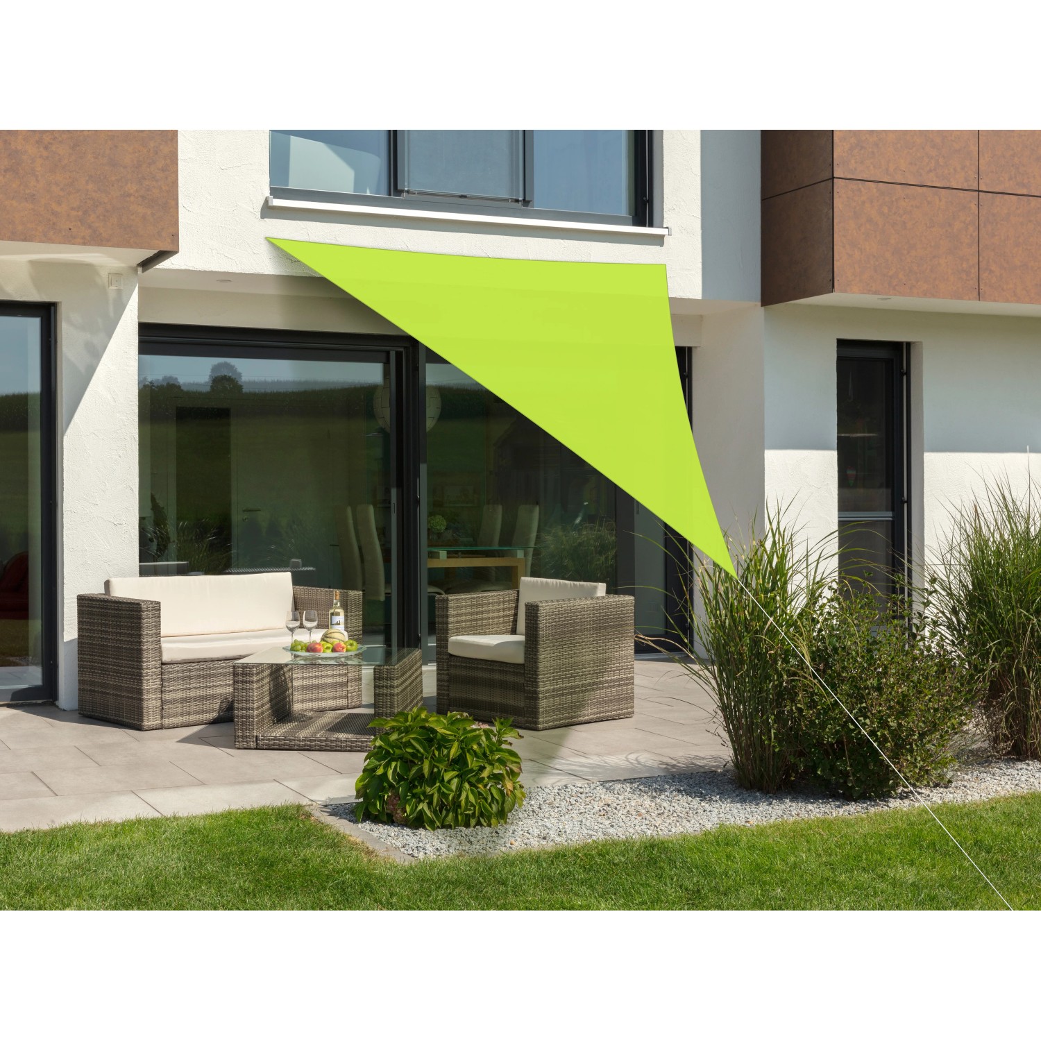 Apfelgrünes Schneider Sonnensegel Lanzarote, dreieckig, 400x400x300 cm, über einer Terrasse mit Gartenmöbeln.