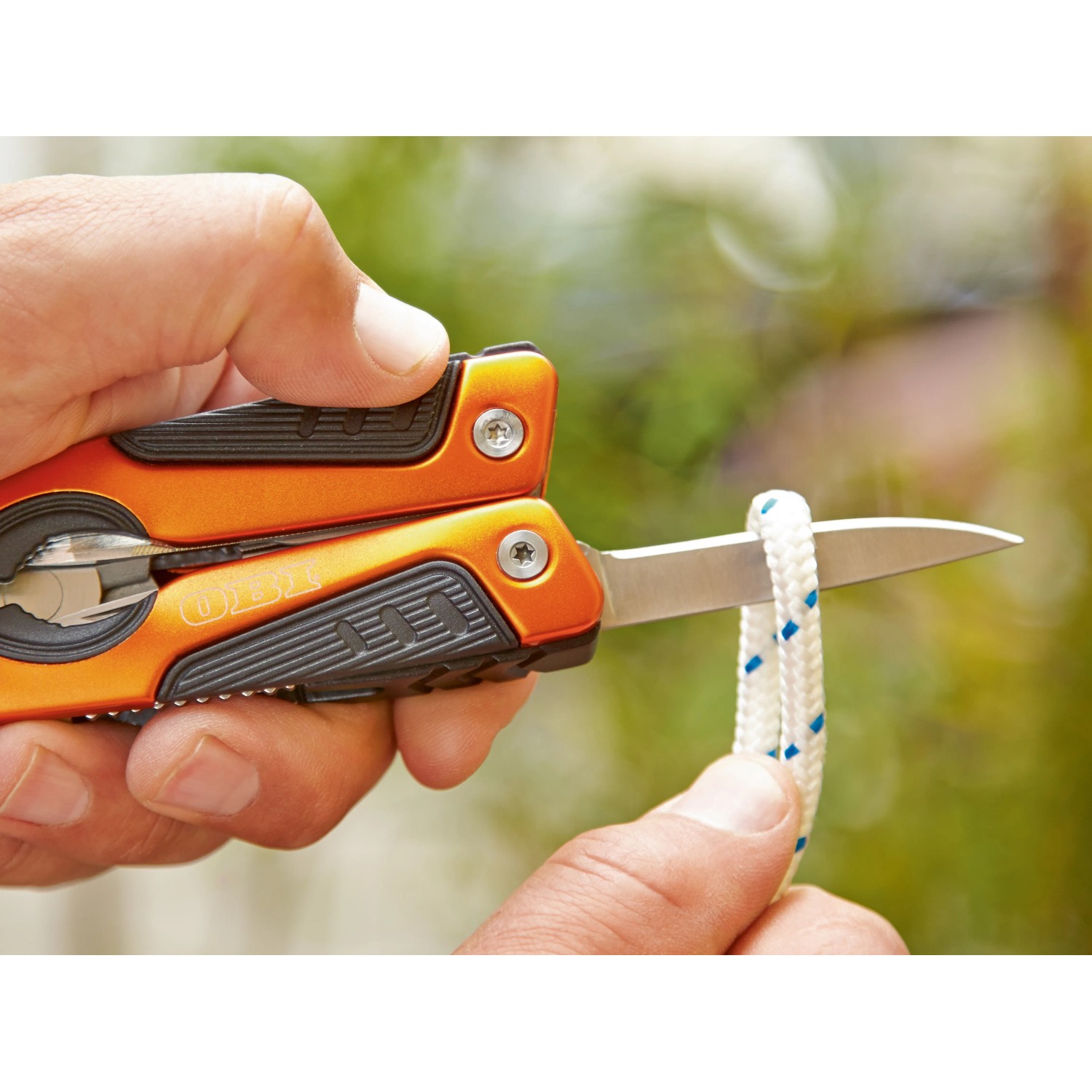 OBI Multitool 12-in-1 Zange schneidet Seil. Vielseitiges Werkzeug mit orangefarbenem Griff.