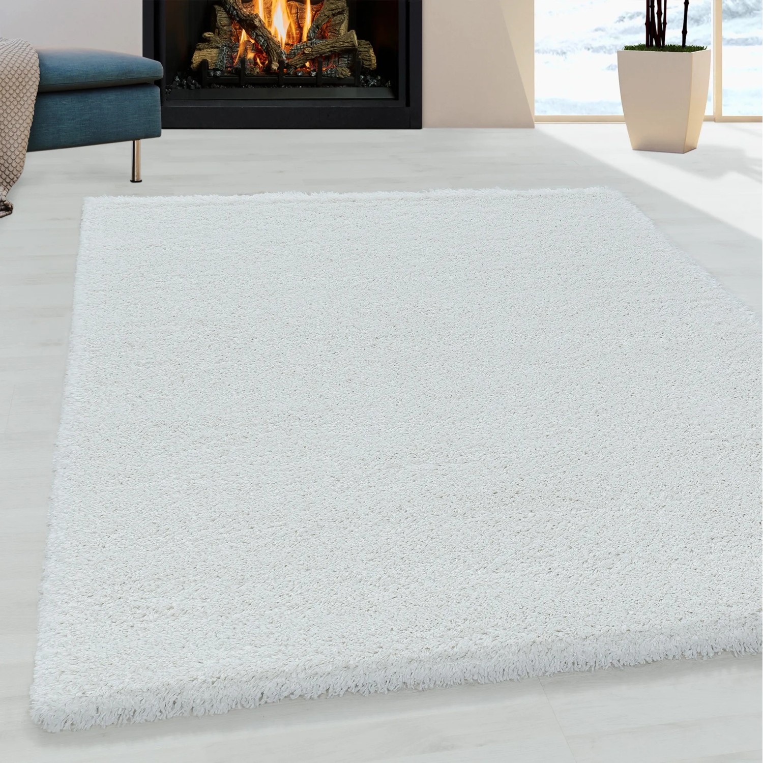 Weißer Ayyildiz Hochflorteppich Fluffy 3500 (280x370 cm) im Wohnzimmer mit Kamin.