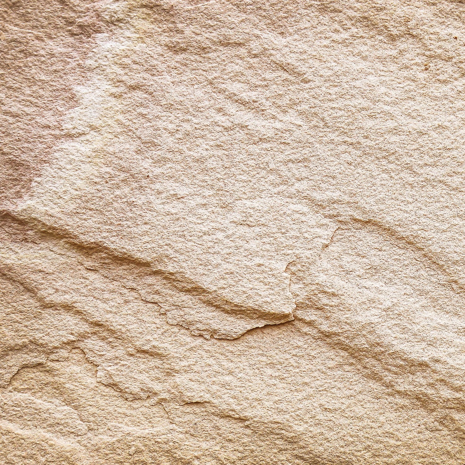 Nahaufnahme eines Galamio Sandstein Randsteins mit gespaltener Oberfläche. Naturstein für rustikale Gartengestaltung.