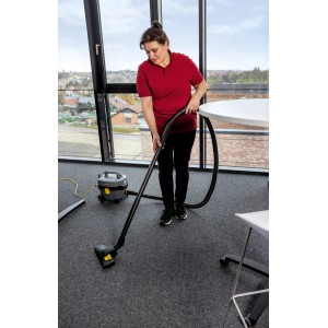 Frau saugt mit Kärcher T 7/1 Classic ADV Trockensauger Büro. Kompakter, leiser Gewerbesauger mit 7 l Behälter.