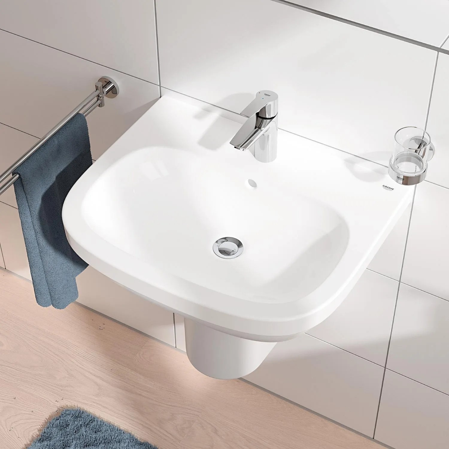 Weißes Waschbecken mit Grohe QuickFix Waschtischarmatur Start S-Size und Handtuchhalter.
