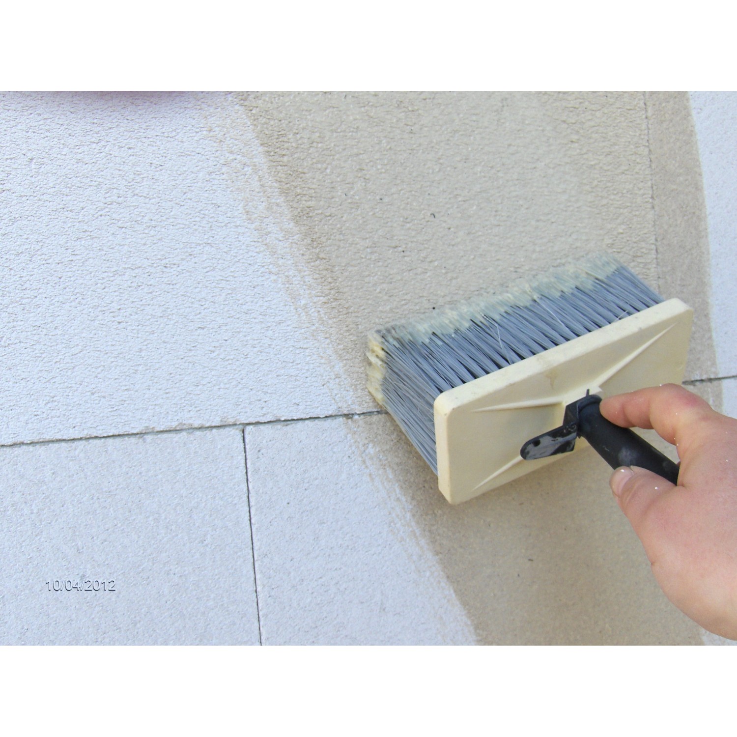 Auftragen der Aufbrennsperre (15 l) mit Quast auf eine Wand. Isoliergrund für Innen- und Außen.