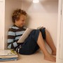 Junge liest unter Osram LED Nachtlicht. Kompakte, dimmbare DOT-it Touch Lampe.