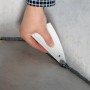 LUX Fugenglätter in Anwendung: Hand glättet graue Silikonfuge an Fliese. Maurerwerkzeug für saubere Fugen.