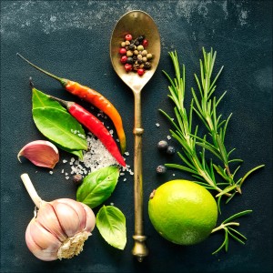 Leinwandbild Vintage Herbage III: Nahaufnahme von Gewürzen, Kräutern und Knoblauch auf dunklem Grund.