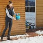 Frau benutzt Gardena Handstreuer M zum Ausbringen von Streugut im Winter.