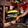 Zusammengeklappter Ryobi Akku-Rasenmäher RLM18X33B40 mit Fangsack und gelben Akzenten wird verstaut.