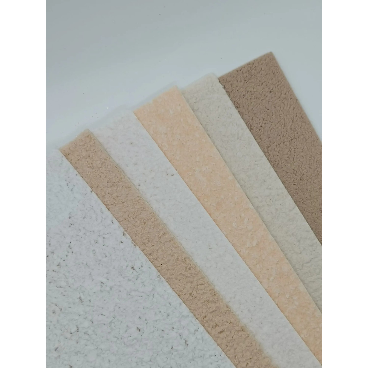 Floxxan Baumwollputz Colorado 124, verschiedene Farbmuster der Flüssigtapete in Lichtgrau und Beige.