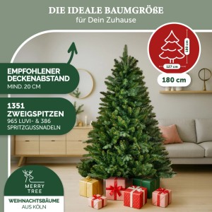 Merry Tree Premium Kunst-Weihnachtsbaum, 180 cm, mit Holzfuß und Geschenken im Wohnzimmer.