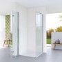 Moderne Aquabatos Eckdusche mit rahmenloser Falttür und Seitenwand aus 5mm ESG Sicherheitsglas in hellem Bad.