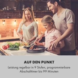 Familie kocht in moderner Küche. Kind rührt in Pfanne auf Induktionskochfeld, Frau schneidet Gemüse. Einbaukochfeld.