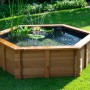 Hexagonaler Gartenteich aus Kiefernholz mit Teichfolie und Bepflanzung im Garten.