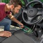 Mann reinigt Auto mit Bosch Akku-Staubsauger EasyVac 12. Handstaubsauger mit Zubehör.