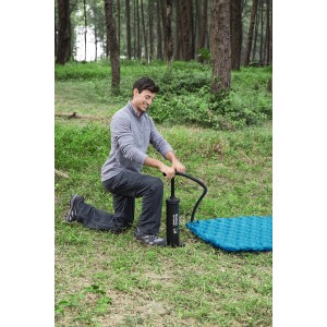 Mann pumpt Luftmatratze mit Bestway Doppelhubpumpe auf. Luftpumpe mit Schlauch und Adapter.