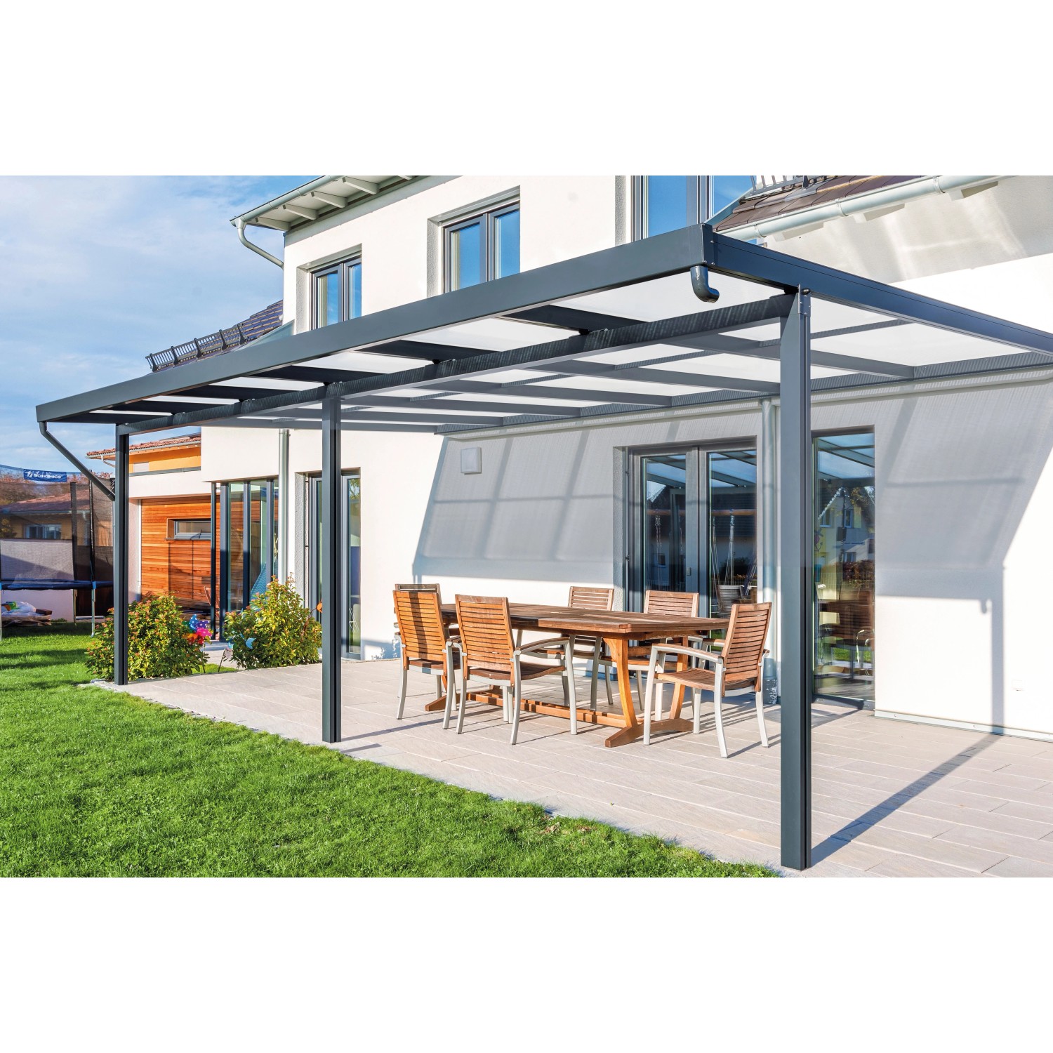 Anthrazitfarbenes Gutta Terrassendach Premium mit Acryl Stegplatten und Sitzgruppe auf Terrasse.