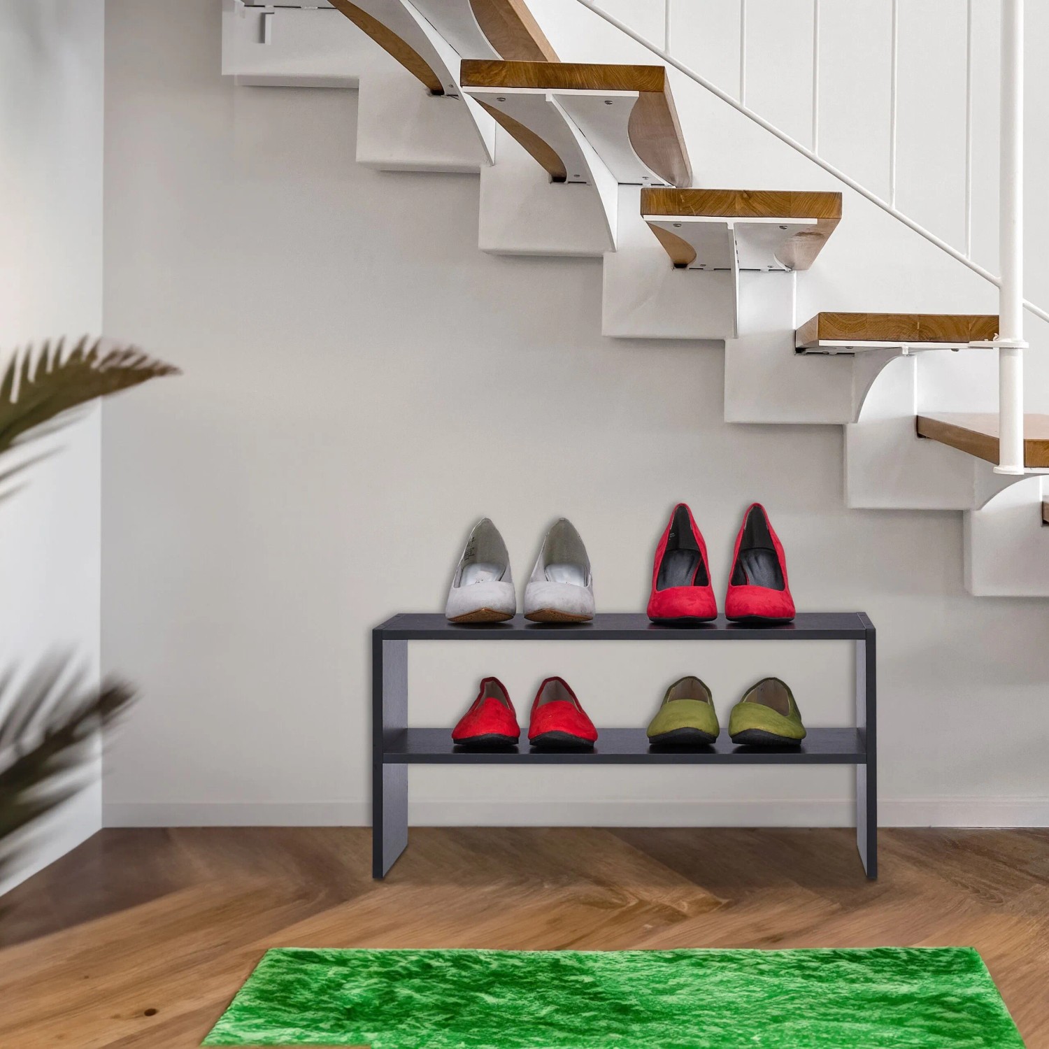 Schwarzes Relaxdays Schuhregal aus Spanplatte mit 2 Ebenen, unter einer Treppe platziert. Platzsparende Schuhaufbewahrung.