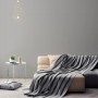 Wohnraum mit grauer AS-Creation Vliestapete Attractive Uni und Couch.