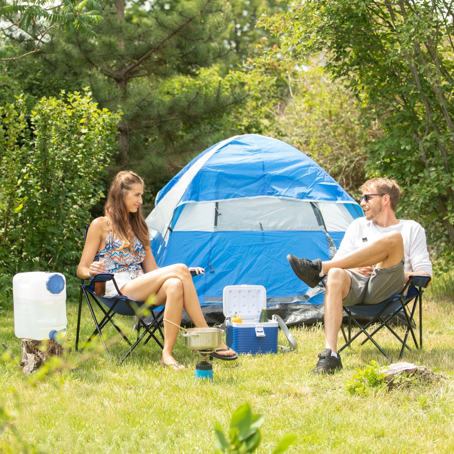 Camping Szene mit Relaxdays Wasserkanister (15L, weiß/blau) neben Zelt und Personen.