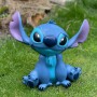 Blaue Stitch Gartenfigur aus Disney, sitzend auf Rasen. Dekorative Figur für Garten und Terrasse.