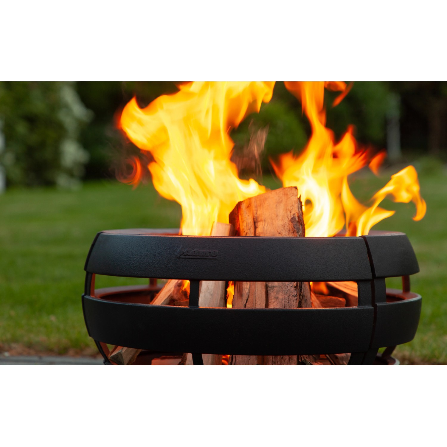 Aduro Feuerball mit Grillfunktion aus Gusseisen, befeuert mit Holz im Garten.
