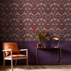 Detailaufnahme der lila William Morris Vliestapete Strawberry Thief mit Vogel- und Erdbeermuster.