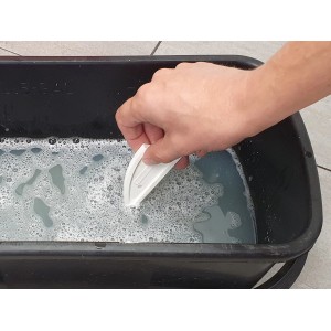 Hand hält Fugenglätter Universal in Wasser. Werkzeug zum Glätten von Fugen.