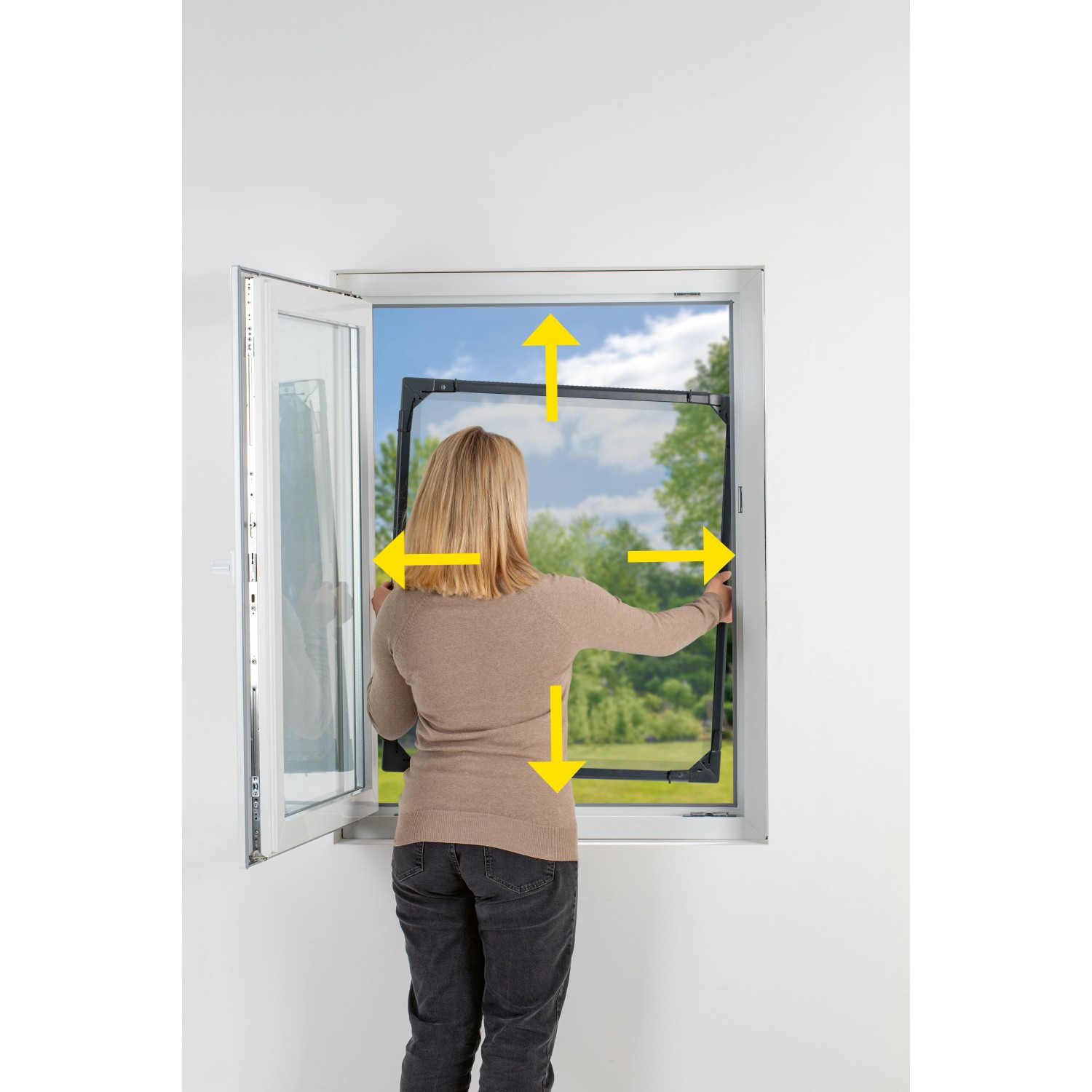 Frau montiert anthrazitfarbenes Easymaxx Moskitonetz Magic Fit am Fenster. Fenster-Zubehör für Insektenschutz.