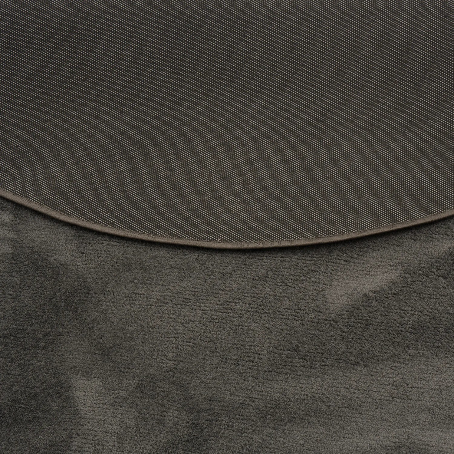 Detailansicht: Anthrazitfarbener, runder Hochflor Teppich Melia (200x200cm) mit rutschfester Unterseite.