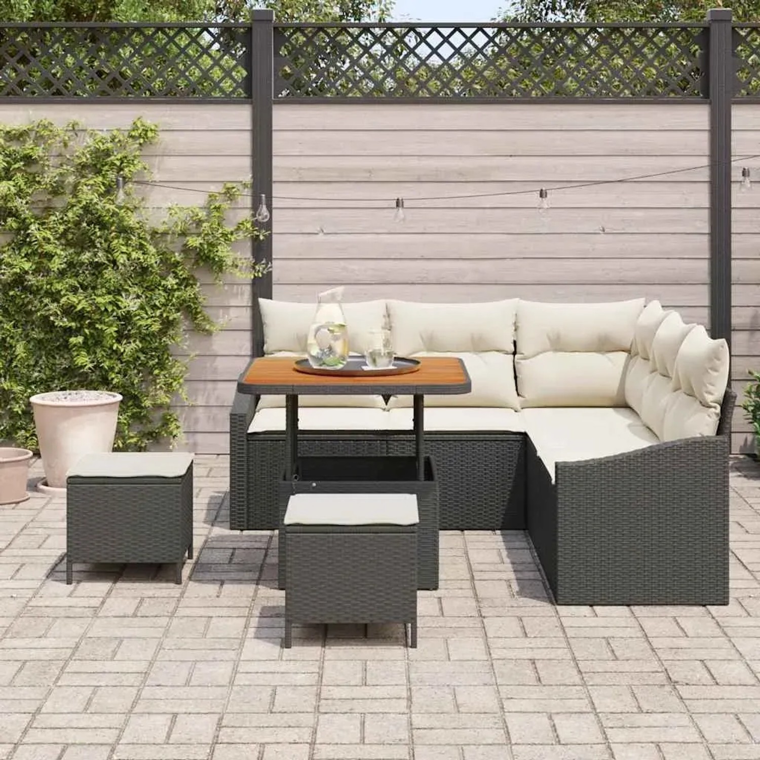 8-teiliges Garten-Sofa-Set aus Poly Rattan und Akazie in Schwarz mit cremefarbenen Kissen.