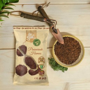 Dr.Soil Pinienrinden Humus 1L Beutel mit Gartengeräten und Schale mit Rindenmulch.