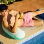 Mann entspannt auf Bestway Pool-Hängematte Comfort Plush am Pool mit Cocktail.