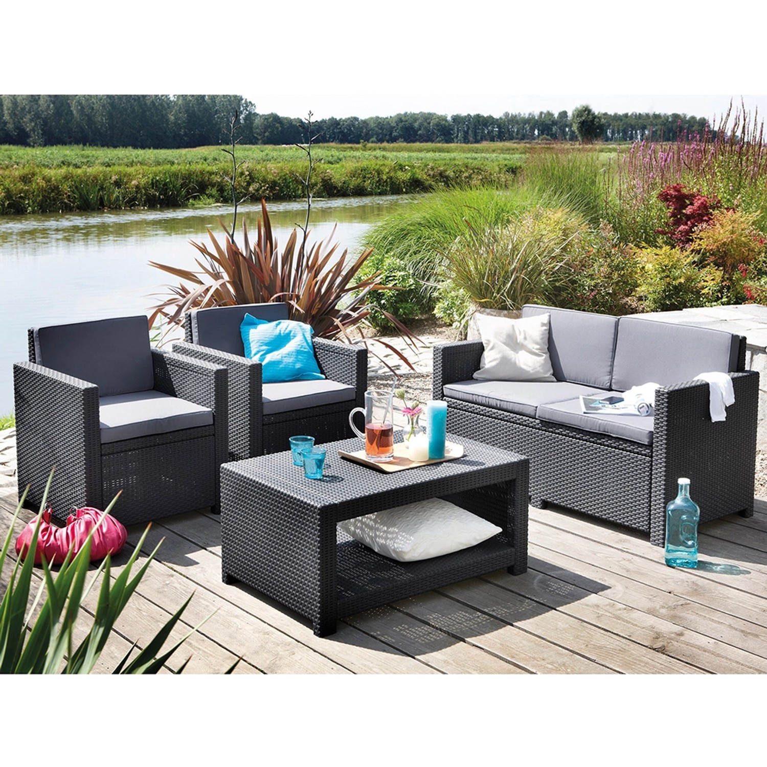 Allibert Loungeset Monaco, 4-teilig, graphitgrau, mit Tisch, Bank und zwei Sesseln im Garten.