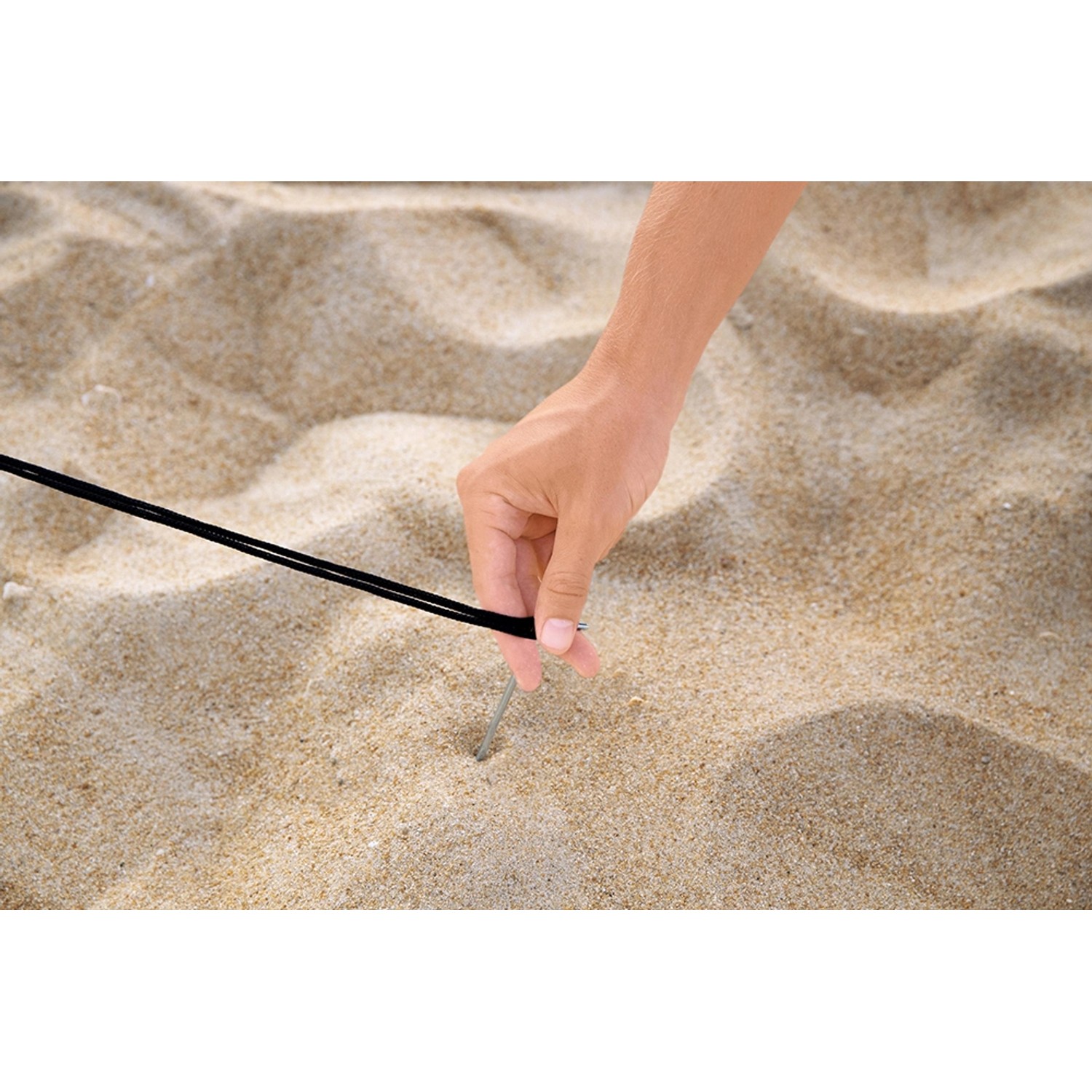 Detailaufnahme: Hand befestigt Hering der Pavillo Strandmuschel im Sand.