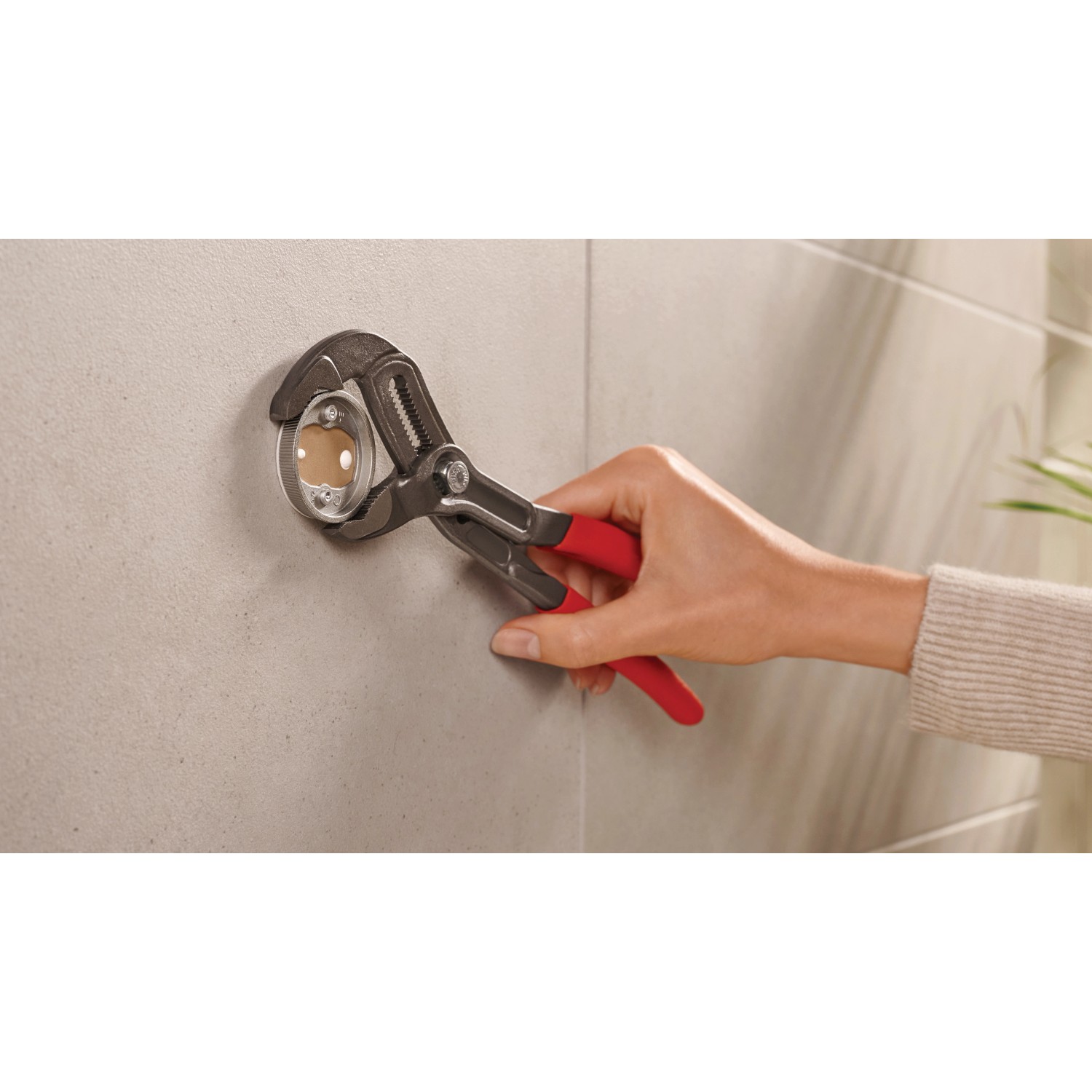 Montage des Tesa Toilettenpapierhalters Moon (Schwarz Matt) mit einer Rohrzange an der Wand.