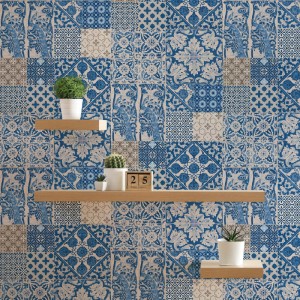 Tadessi Vliestapete Fliesenoptik in Blau und Creme, mit Patchwork-Muster, floralen und geometrischen Ornamenten an der Wand.